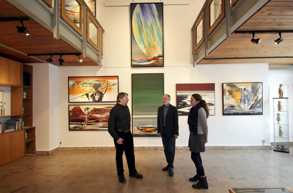 Künstler Christian Lang (M.) unterhält sich vor seinen großformatigen Bildern in der Galerie Schmidt-Rottluff mit den Galeristen Friedrich Preis (l.) und Elisabeth Preis (r.). Foto: bit