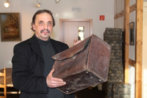 Restaurator Thomas Heinicke aus Wickersdorf mit einem historischen Reisekoffer des Lichtensteiner Museums. Er hat auch schon wertvolle Taschenuhren zum Schätzen vorgelegt bekommen. Foto: Uwe Wolf