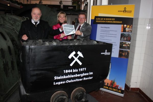 Ein Foto aus dem Jahr 2013. Volker Uhlig, Landrat Landkreis Mittelsachsen und Sprecher des Welterbekonvents, Veronika Hiebl, Geschäftsführerin Tourismusverband Erzgebirge und Matthias Lißke, Geschäftsführer Wirtschaftsförderung Erzgebirge (v.l.n.r.) präsentieren das „erzgebirgisch“-Siegel im Bergbaumuseum Oelsnitz. Foto: Wirtschaftsförderung Erzgebirge