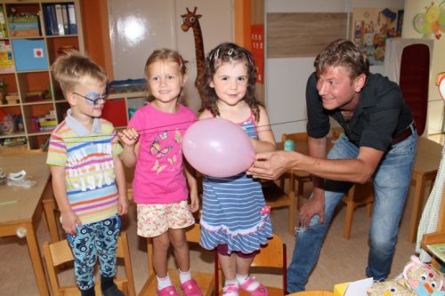 Jake, Leoni und Tina von der Schmetterlingsgruppe sind begeistert, wie Michael Gobsch mit einem Luftballon ein kleines Röhrchen am Faden gleiten lassen kann. Foto: Uwe Wolf